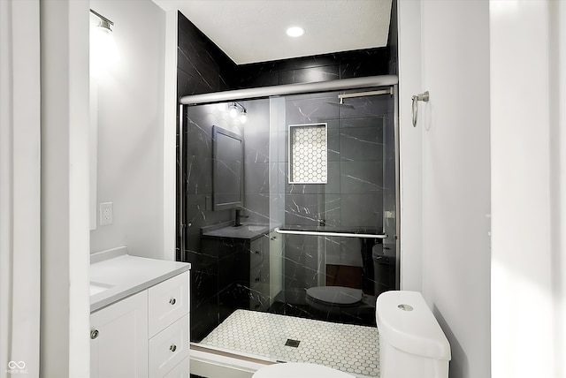 bathroom with a stall shower, vanity, and toilet