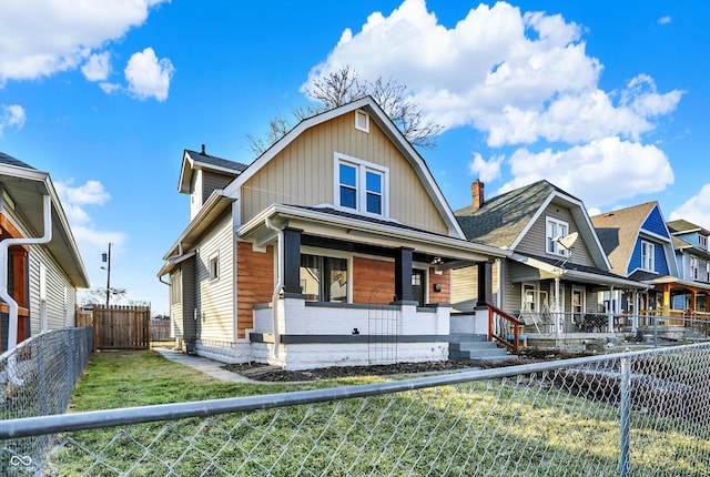 view of front of house featuring covered porch, a front lawn, and fence private yard