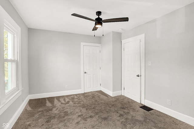 unfurnished bedroom featuring carpet, visible vents, ceiling fan, and baseboards