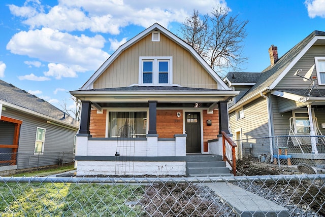 dutch colonial with a fenced front yard and a porch