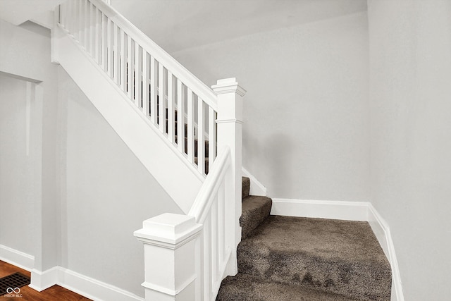 staircase featuring baseboards and wood finished floors