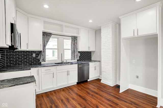 kitchen featuring appliances with stainless steel finishes, dark wood finished floors, white cabinets, and a sink