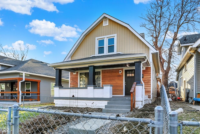 view of front of property featuring covered porch, roof with shingles, and fence