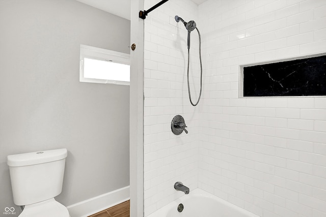 bathroom with toilet, shower / bathing tub combination, baseboards, and wood finished floors