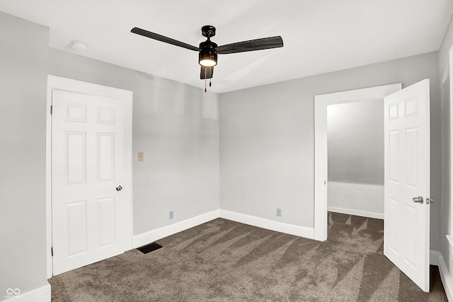 unfurnished bedroom featuring ceiling fan, dark carpet, visible vents, and baseboards