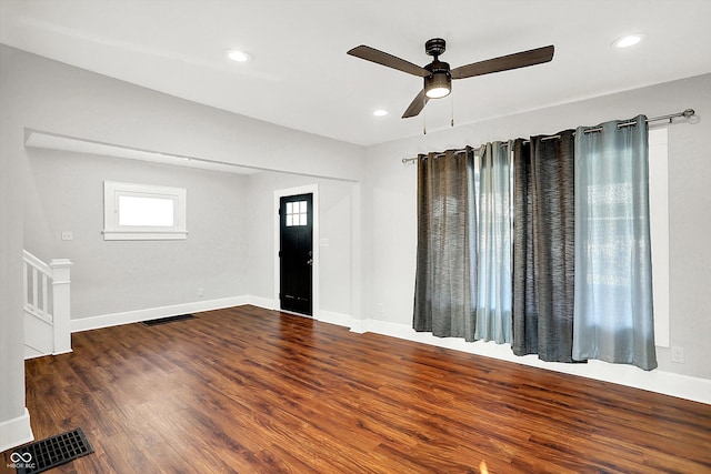 spare room featuring wood finished floors, visible vents, and baseboards