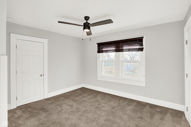 unfurnished room with dark carpet, baseboards, and ceiling fan