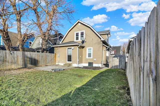 rear view of house with a lawn, a gambrel roof, a patio area, cooling unit, and a fenced backyard