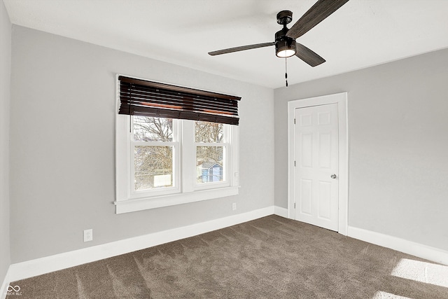 unfurnished bedroom featuring a ceiling fan, dark colored carpet, and baseboards