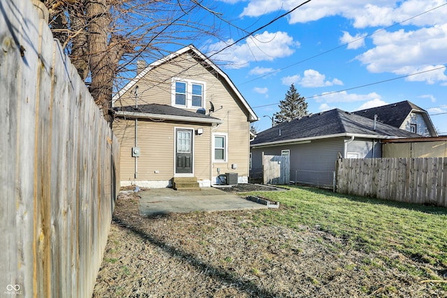 back of house featuring entry steps, central AC unit, fence, a yard, and a patio area