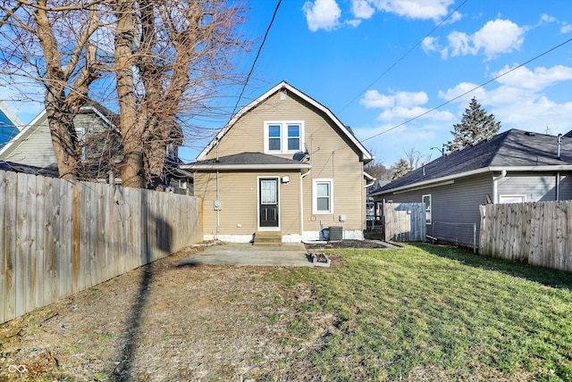 back of property featuring entry steps, a fenced backyard, a yard, and a gambrel roof