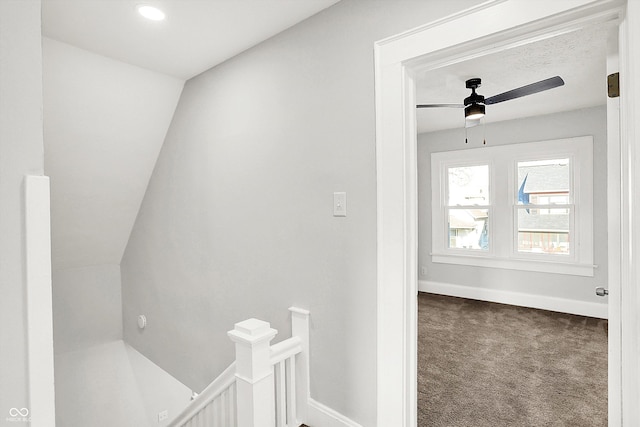 hall with carpet flooring, an upstairs landing, and baseboards