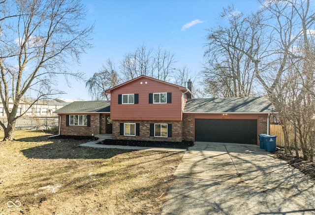 tri-level home featuring driveway, brick siding, an attached garage, fence, and a front yard