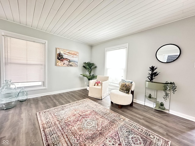 living area featuring wooden ceiling, baseboards, and wood finished floors