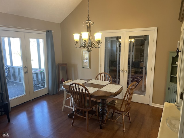 dining space with dark wood finished floors, a notable chandelier, french doors, and vaulted ceiling