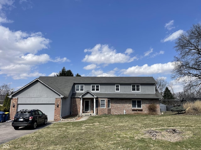 traditional-style home featuring driveway, brick siding, an attached garage, and a front lawn