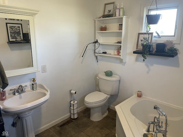 bathroom with visible vents, toilet, tile patterned flooring, baseboards, and a bath