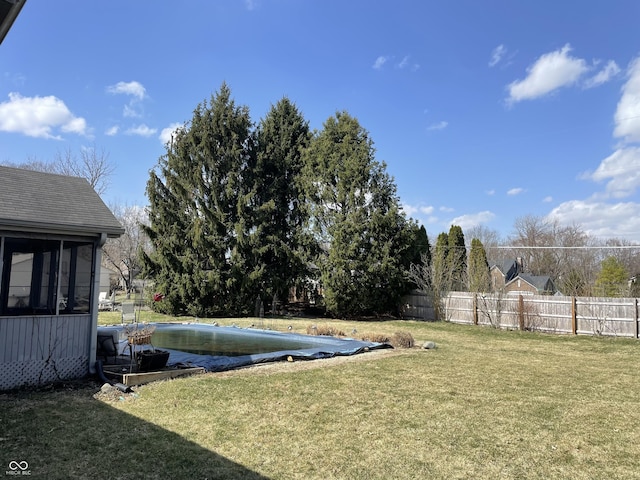 view of yard featuring a fenced in pool, a sunroom, and fence