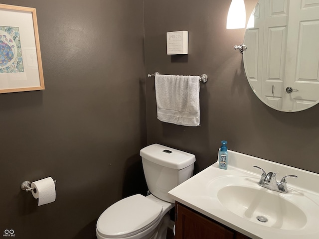 half bathroom with vanity and toilet