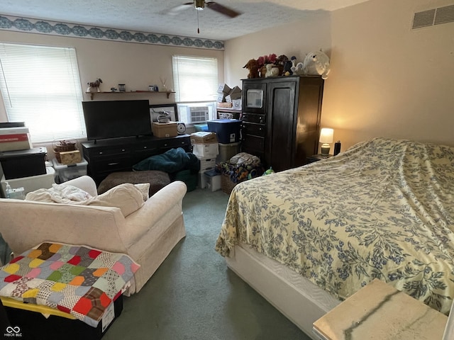 carpeted bedroom featuring visible vents, a textured ceiling, and ceiling fan