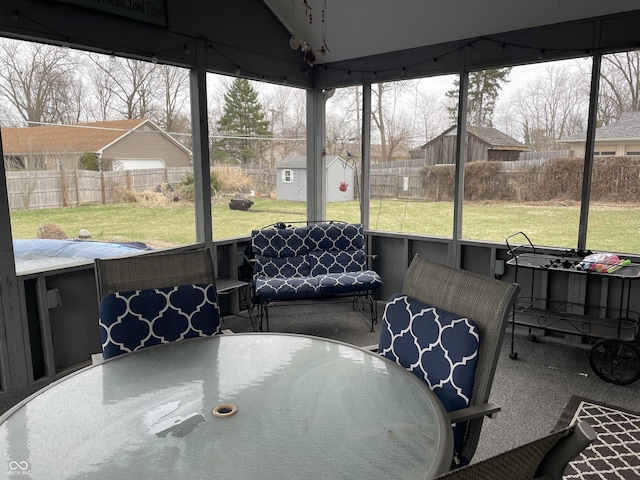 sunroom / solarium featuring a residential view and vaulted ceiling