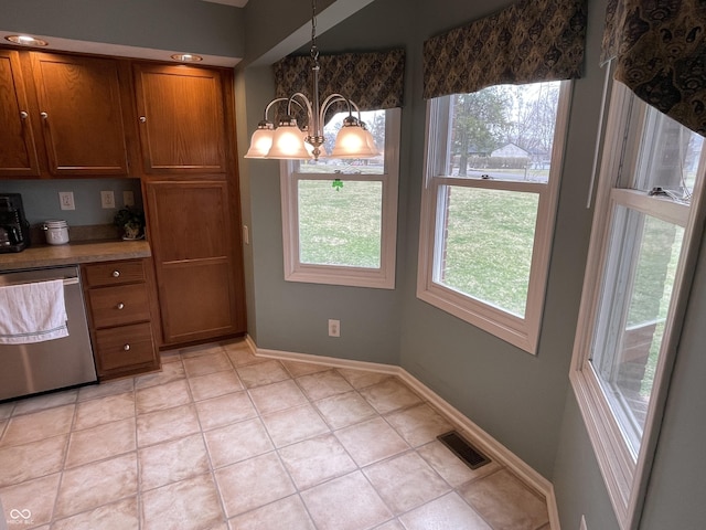 kitchen featuring brown cabinetry, visible vents, baseboards, an inviting chandelier, and stainless steel dishwasher