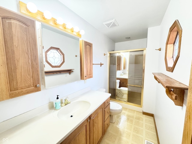 bathroom featuring visible vents, toilet, a stall shower, vanity, and tile patterned floors