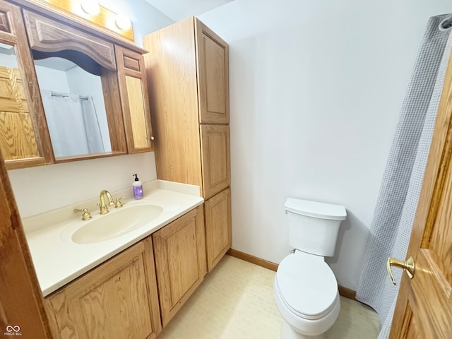 full bathroom with toilet, baseboards, and vanity