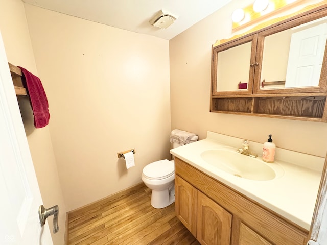 bathroom featuring vanity, toilet, and wood finished floors