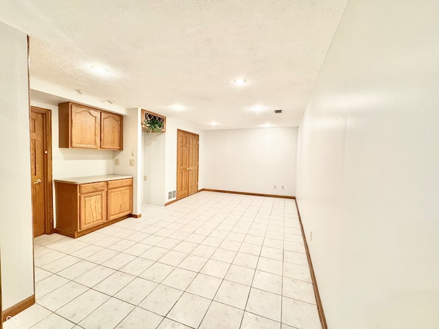 kitchen with visible vents, baseboards, light countertops, and a textured ceiling