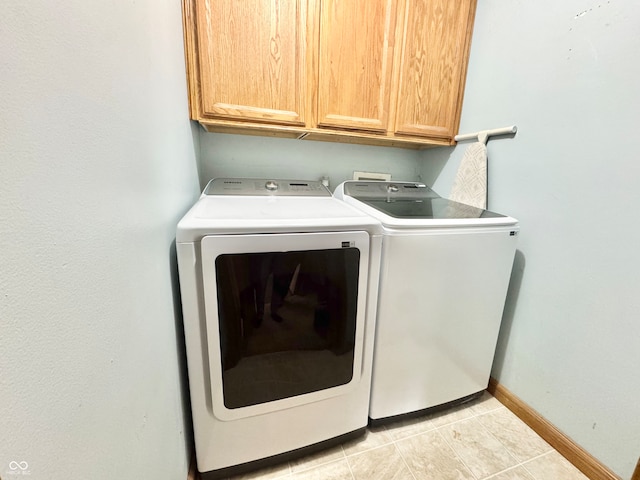 laundry room featuring cabinet space, light tile patterned floors, baseboards, and separate washer and dryer