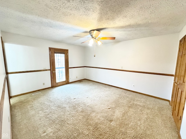 empty room featuring light carpet, baseboards, visible vents, and ceiling fan