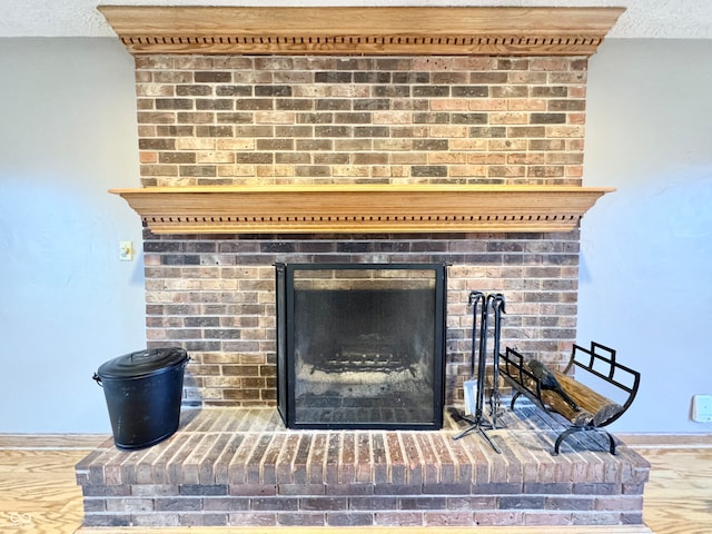 details with a brick fireplace and a textured ceiling