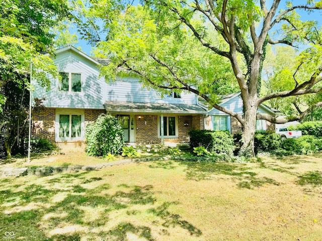 view of front of home with a front lawn and brick siding