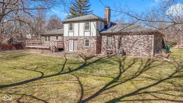 back of house with a chimney, fence, a deck, a yard, and stucco siding