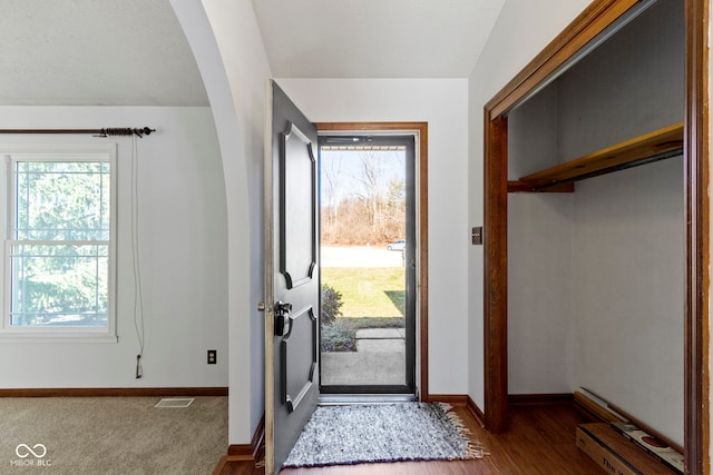 entrance foyer featuring arched walkways, visible vents, and baseboards