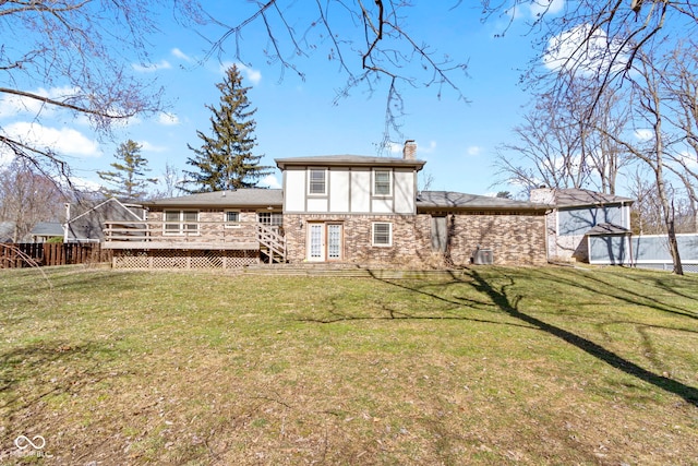 rear view of property featuring a deck, a lawn, a chimney, and fence