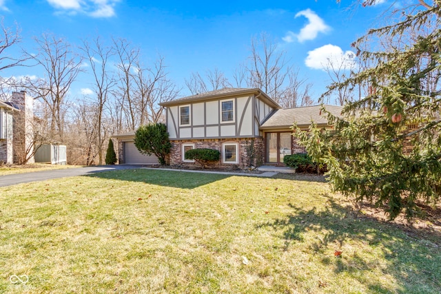 tudor-style house with a front yard, driveway, an attached garage, and stucco siding