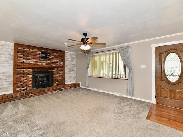 unfurnished living room featuring carpet floors, visible vents, ornamental molding, a brick fireplace, and baseboards