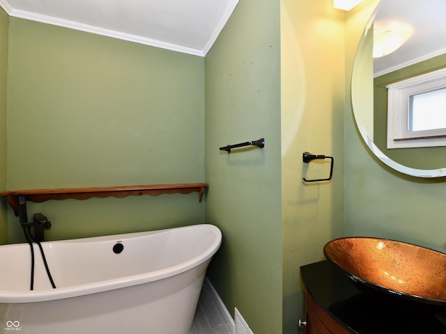 bathroom featuring crown molding, vanity, and a freestanding bath