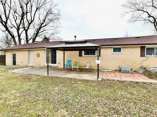 back of house featuring a yard, a gazebo, a patio, and brick siding