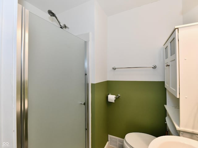 bathroom featuring a stall shower, visible vents, and toilet