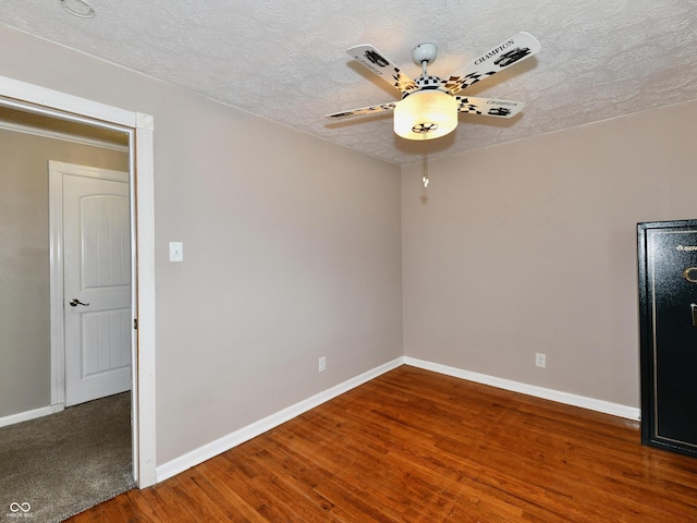 unfurnished room with ceiling fan, a textured ceiling, baseboards, and wood finished floors