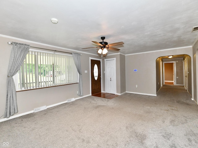 interior space with arched walkways, carpet flooring, visible vents, and crown molding