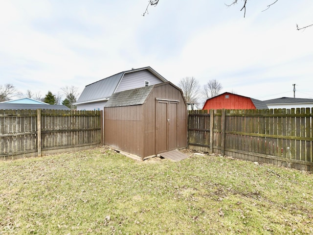 view of yard with an outbuilding, a fenced backyard, and a storage shed