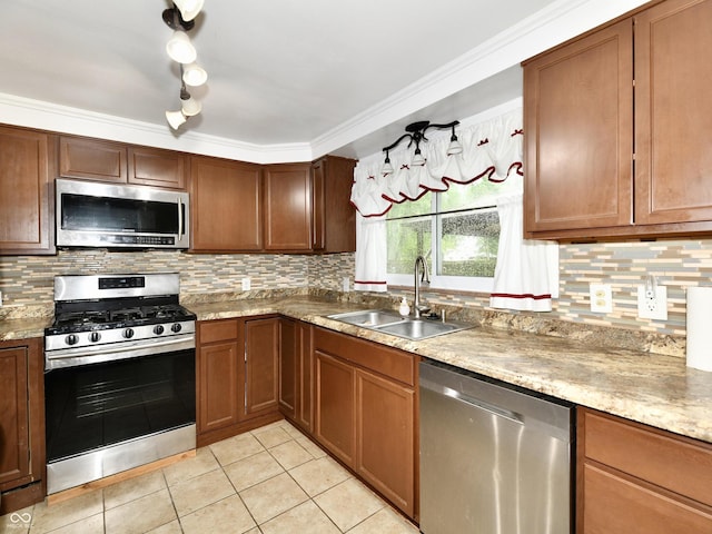 kitchen featuring backsplash, appliances with stainless steel finishes, light tile patterned flooring, a sink, and light stone countertops