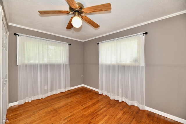 unfurnished room featuring ornamental molding, wood finished floors, and baseboards