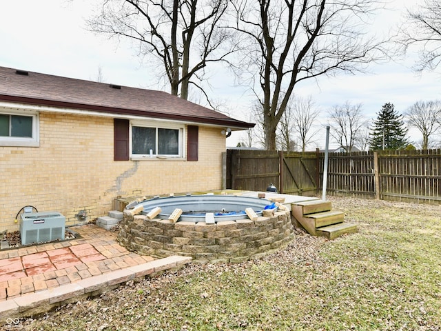 view of yard with a fenced backyard, a patio, and central AC unit