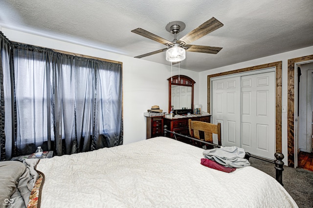 carpeted bedroom with a textured ceiling, a closet, and a ceiling fan