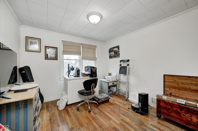 office space featuring ornamental molding, baseboards, and hardwood / wood-style floors